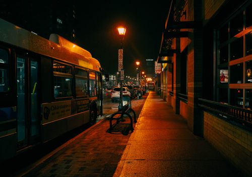 Free A bus parked at a stop under glowing streetlights in London, Ontario, showcasing vibrant city life at night. Stock Photo