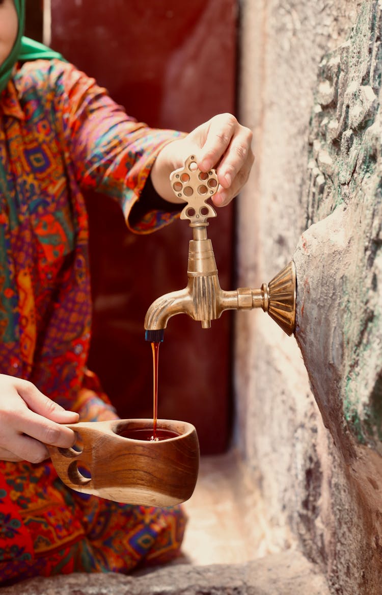 Woman Pouring Liquid To Cup