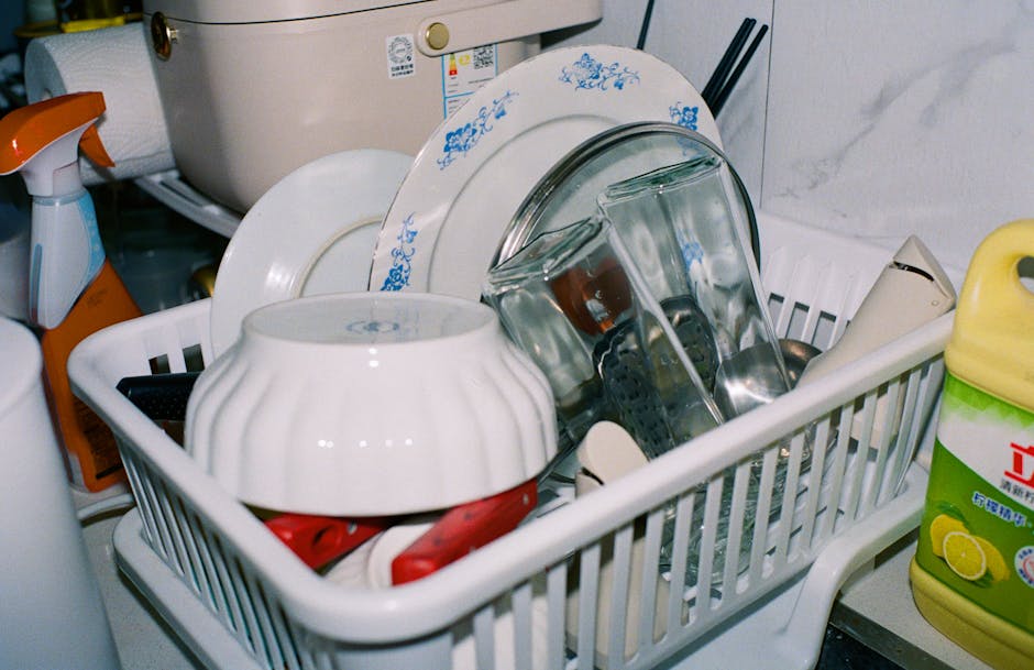 Spring Cleaning Guide Montreal 3 SPRING CLEANING GUIDE MONTREAL - CLEAN KITCHENWARE INCLUDING PLATES AND GLASSES DRYING IN A DISH RACK WITH CLEANING SUPPLIES NEARBY.