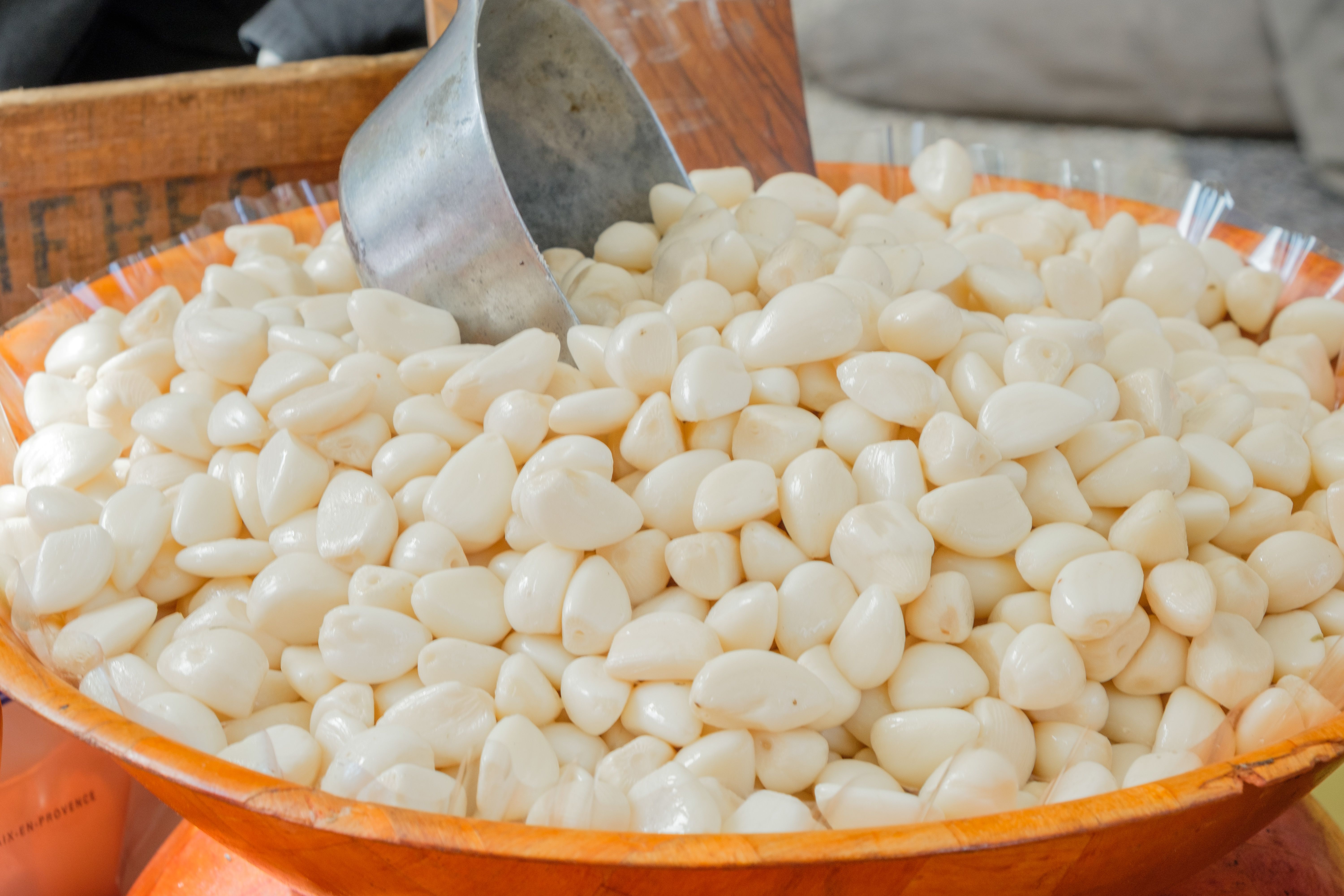 Free Close-up of fresh peeled garlic cloves displayed in a wooden bowl at a market in Aix-en-Provence. Stock Photo