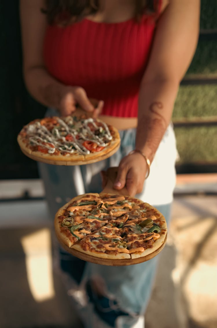 Woman Holding Small Pizzas