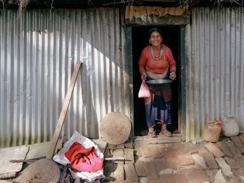 Village Woman at Doorstep of Corrugated Metal House