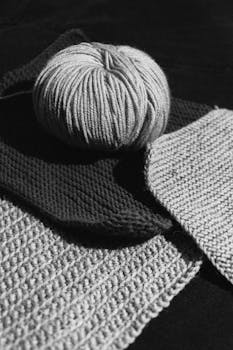 Monochrome photo of yarn ball and knitted fabrics showcasing texture.