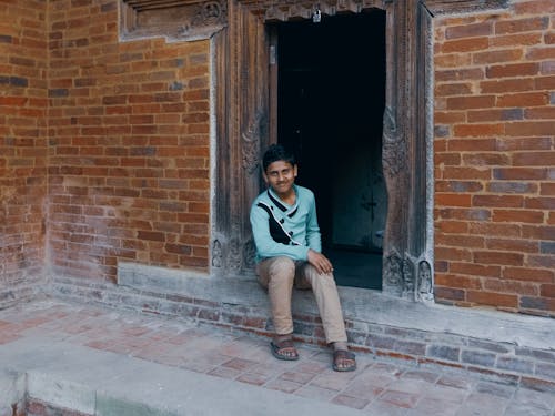 Young Man Sitting at Temple Doorstep