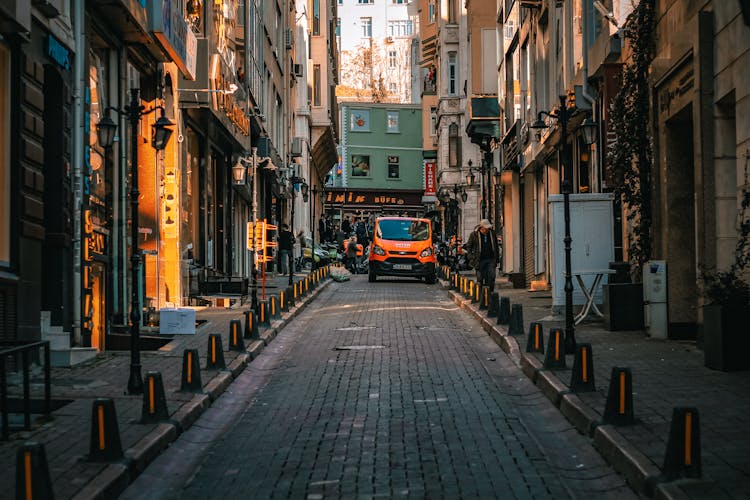 Van Parked On The Street Between Shops