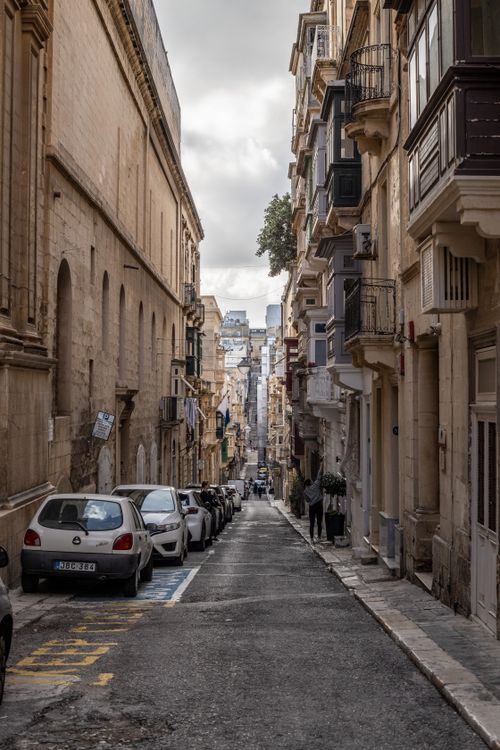 Free Explore the charm of a narrow European street lined with historical architecture. Stock Photo