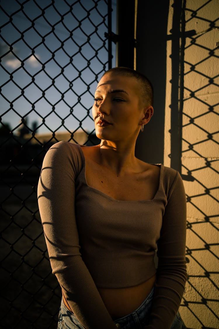 Bald Woman Posing Near Net Fence