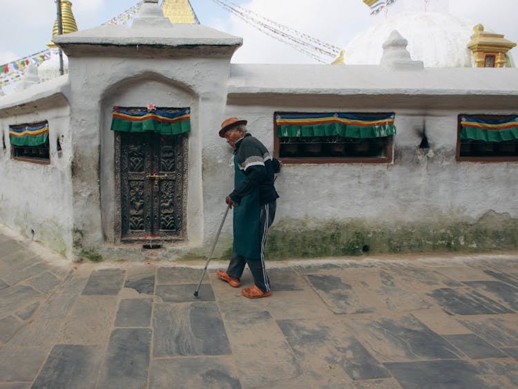 Man Walking With A Cane