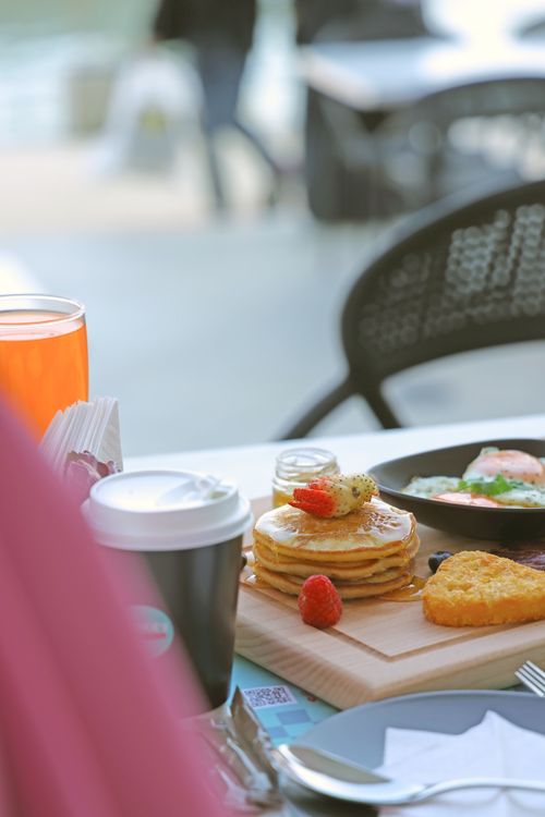 Free Mouthwatering breakfast featuring pancakes, coffee, and toast in a cozy café setting. Stock Photo