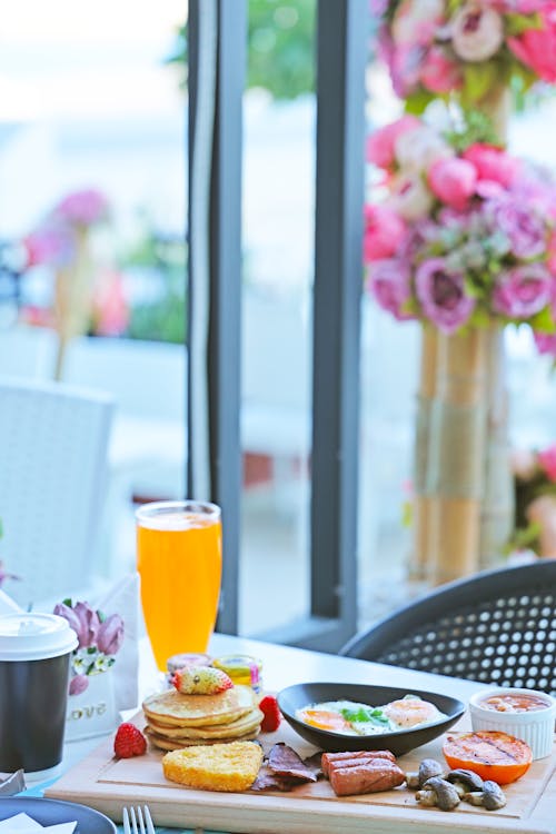 A breakfast table with a plate of food and drinks