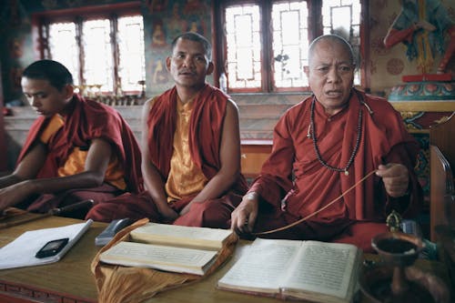 Monks in Traditional Clothes Praying in Temple