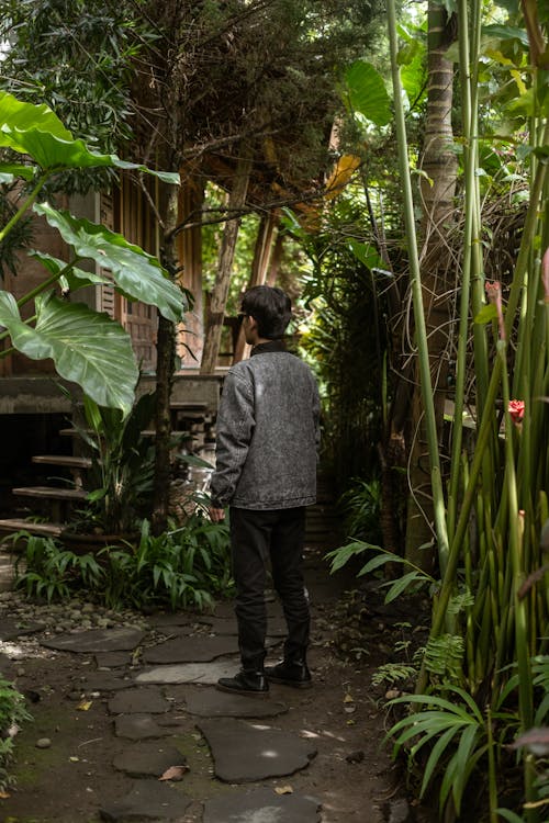 Back View Shot of a Man in Denim Jacket Standing on a Walkway 3