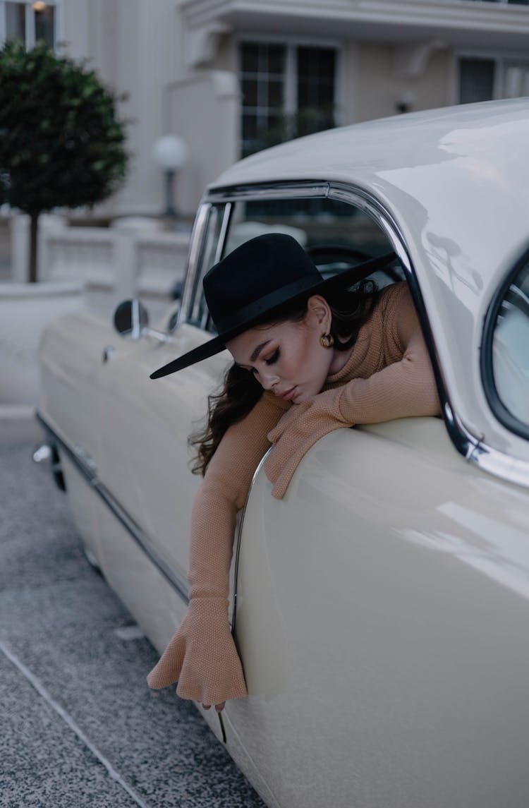 Woman In Hat Leaning Out From Vintage Car