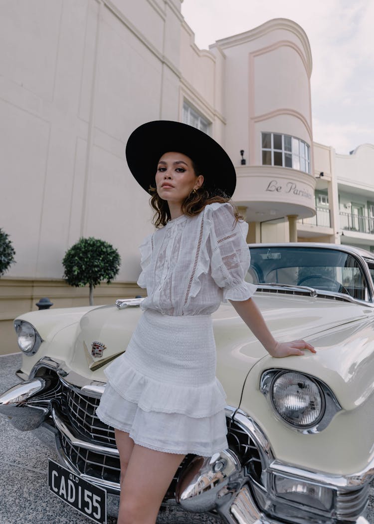 Woman In Hat And Skirt Posing By Vintage Car