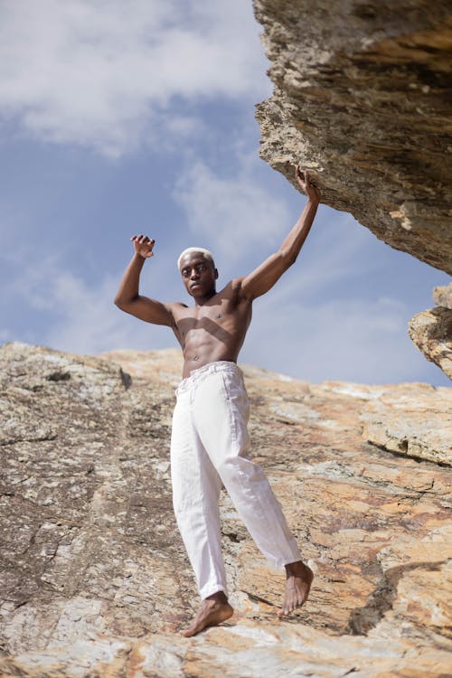 Muscled Man Posing near Rocks