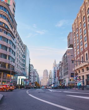 Explore the bustling atmosphere of Gran Vía, Madrid, captured with vibrant street life and iconic architecture.