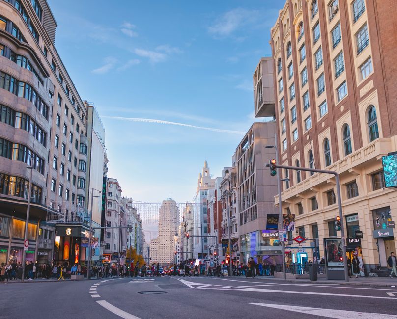 Escena de calle bulliciosa en la icónica Gran Vía, el famoso centro de entretenimiento de Madrid.