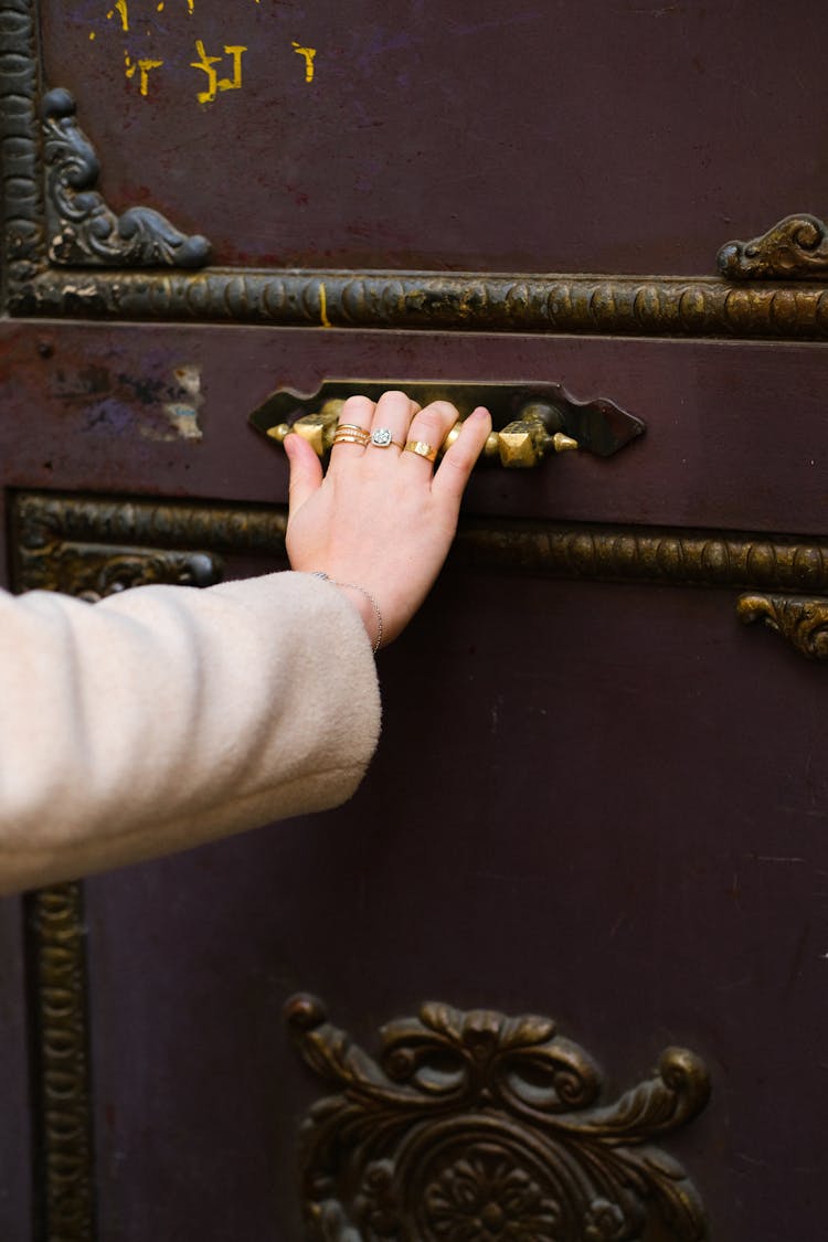 Woman Hand With Rings Opening Old Wooden Doors