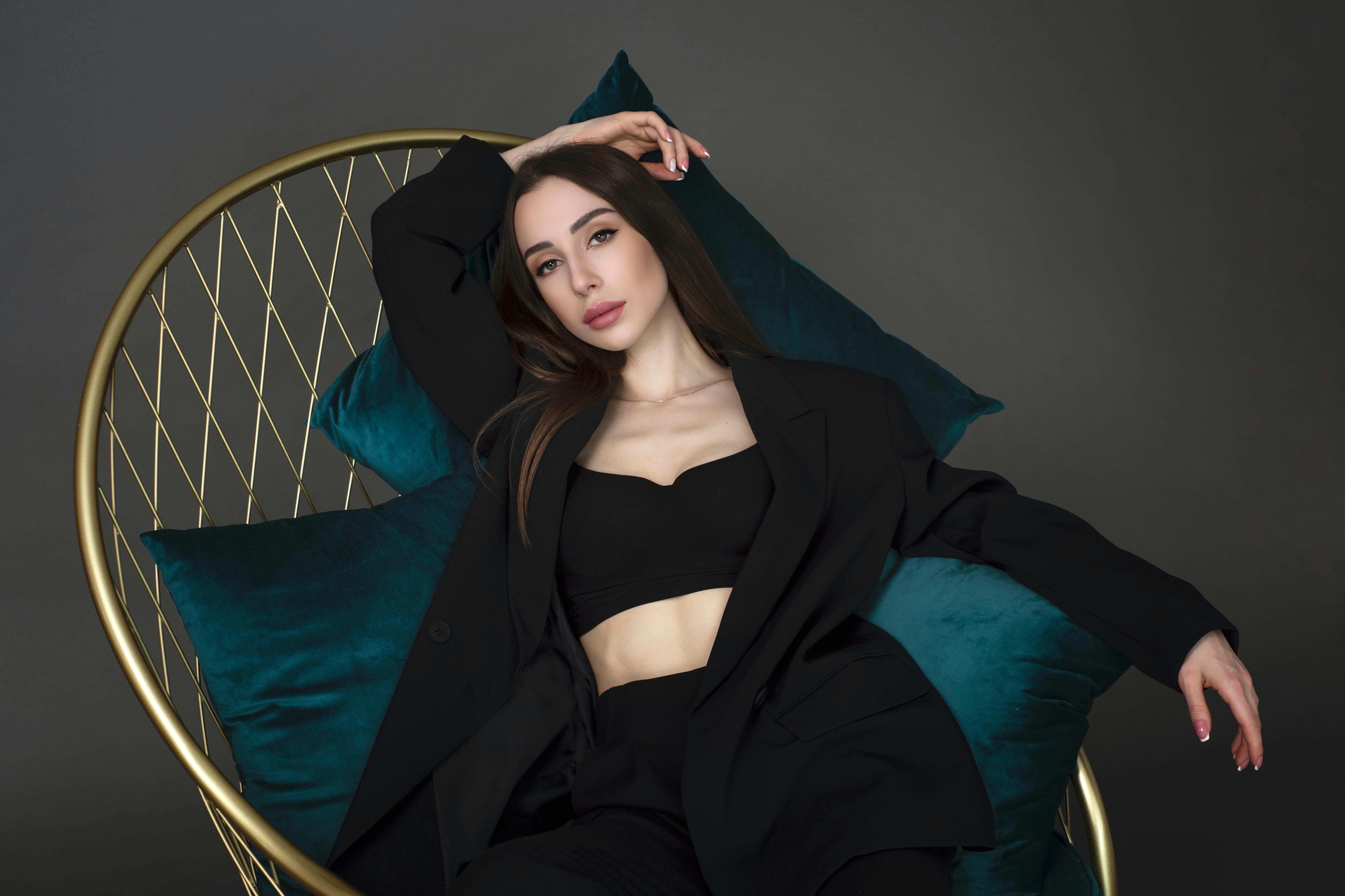 photo of a woman in a black blazer posing on a chair