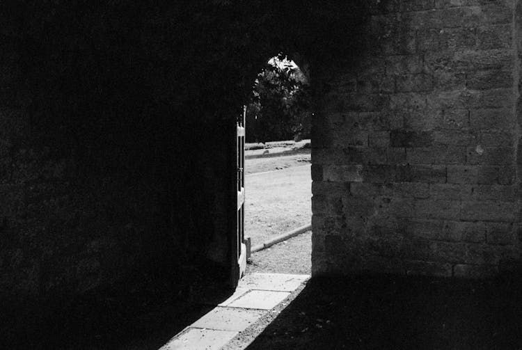 Open Doors In Brick Wall Into Garden