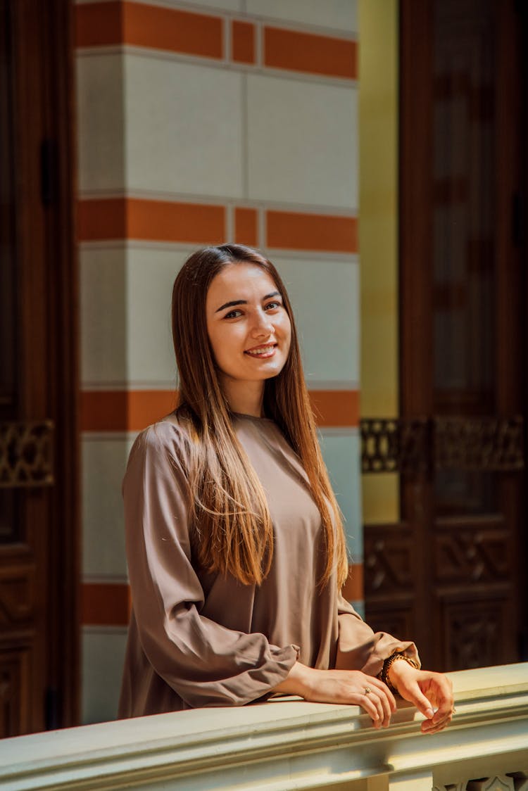 Photo Of A Smiling Girl Standing On A Balcony 