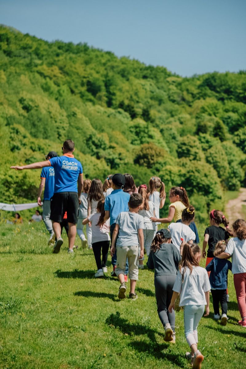 Children with coaches walking outdoors during a school trip