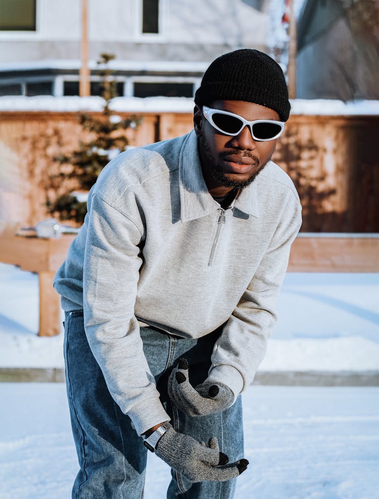 A Man In Gray Sweater And Gloves Out In The Snow