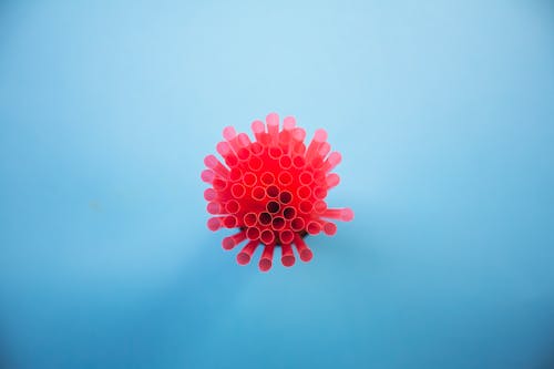 Top View of a Bunch of Pink, Plastic Straws on Blue Background 