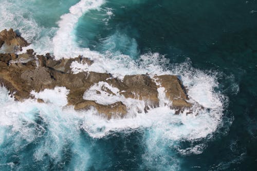 Top View of Waves Crashing on a Rocky Shore 