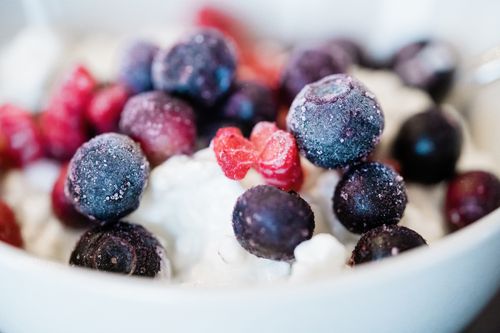 Free A macro shot showcasing frozen blueberries and raspberries on a creamy base, highlighting vibrant colors and textures. Stock Photo