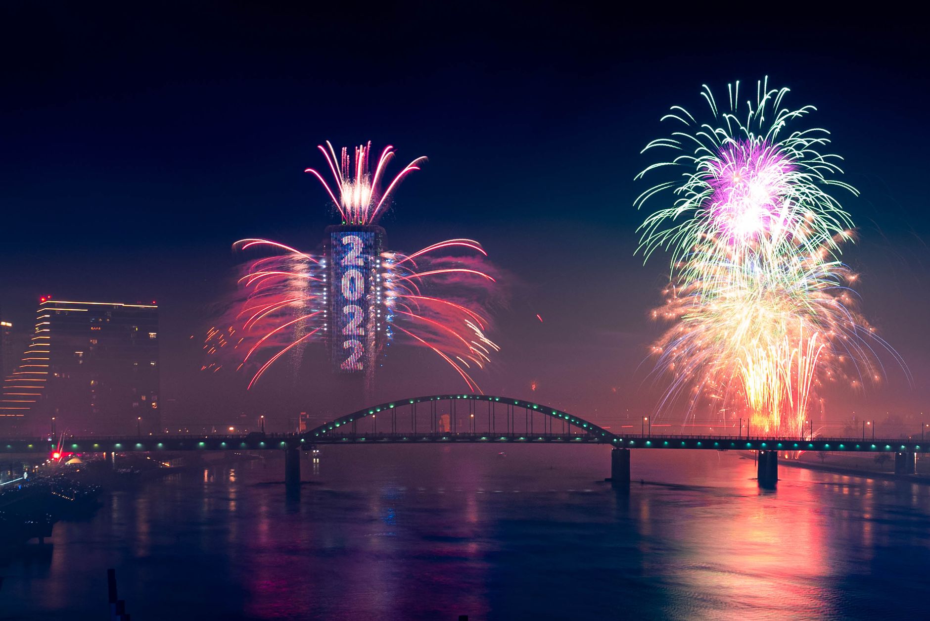 Vibrant fireworks light up the night sky over a bridge in Belgrade, Serbia, ringing in the New Year 2022.