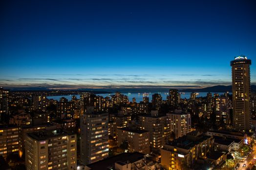 A breathtaking aerial view of Vancouver's vibrant skyline at night, showcasing modern architecture and city lights.