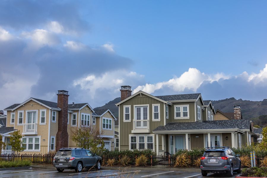 Suburban street of modern houses with cars parked in the driveways