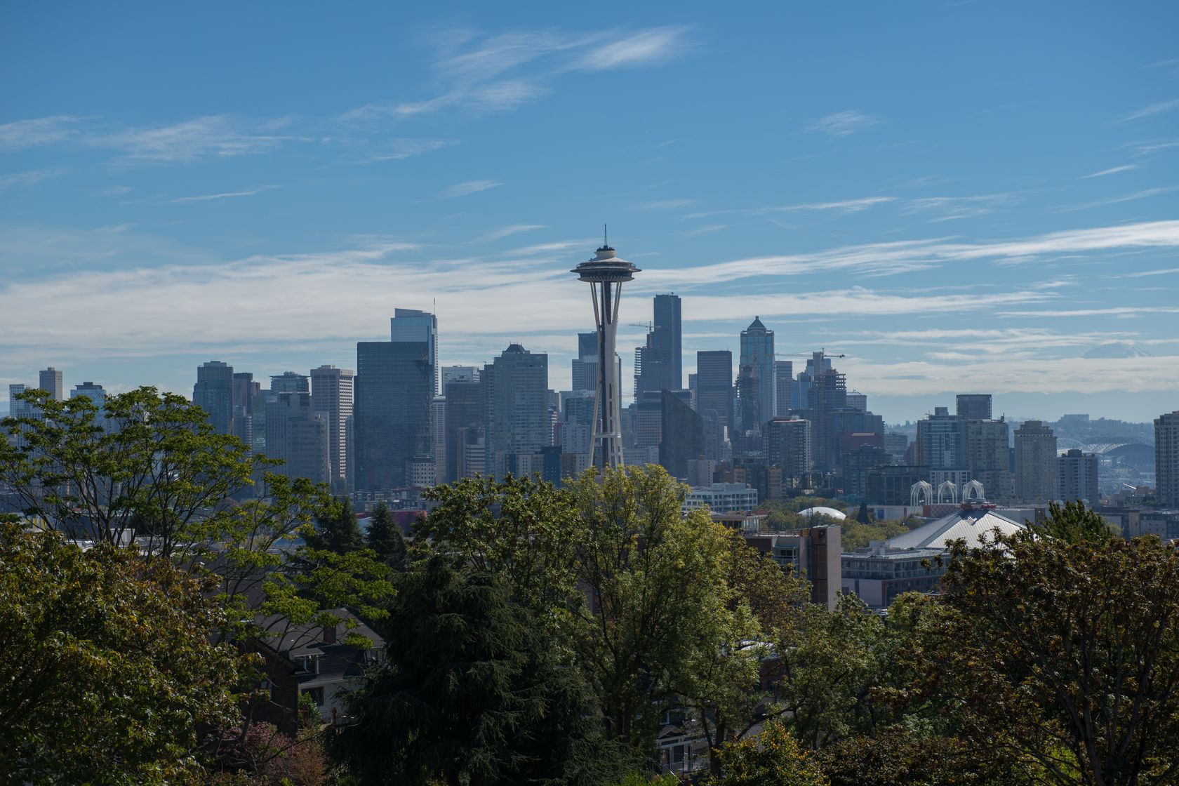 Panoramic view of Seattle with the iconic Space Needle under a clear blue sky.
