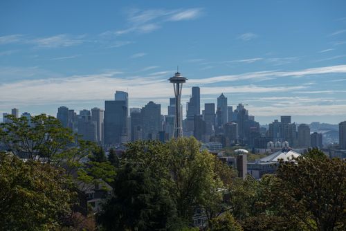 Free Panoramic view of Seattle with the iconic Space Needle under a clear blue sky. Stock Photo