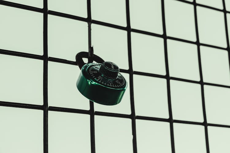 Close-up Of A Padlock On A Mesh Grill