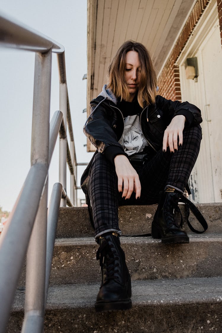 Woman In Black Leather Boots Sitting On Stairs 