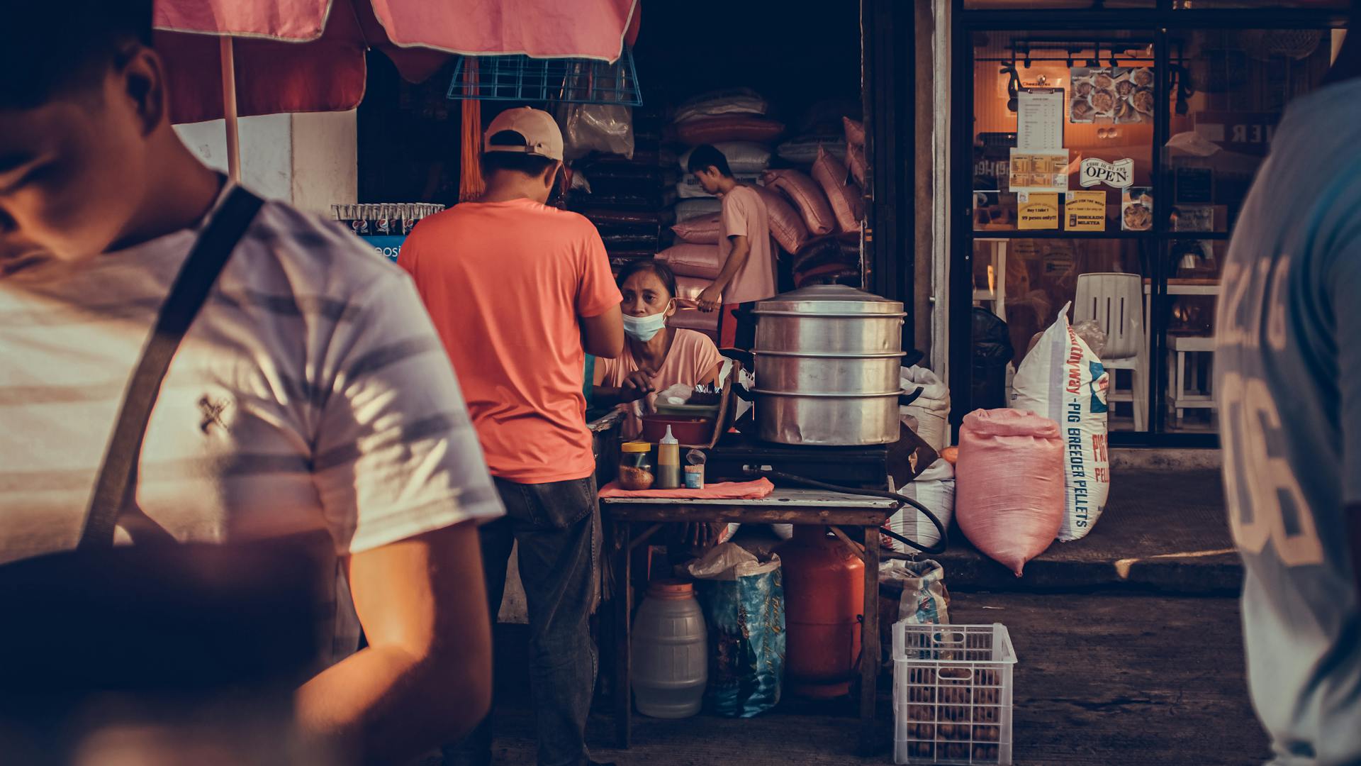 Vibrant street food scene in a Philippine market with people shopping and selling.