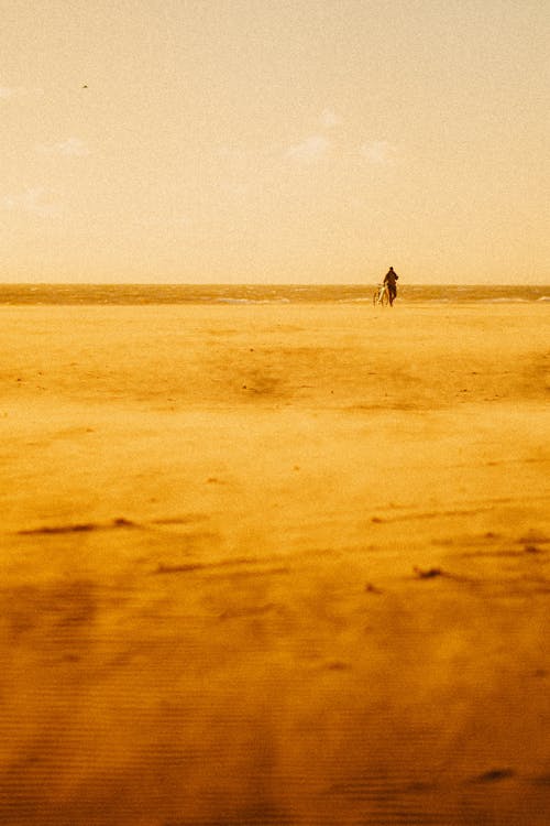 Film Photograph of a Person Walking in Distance on a Beach 