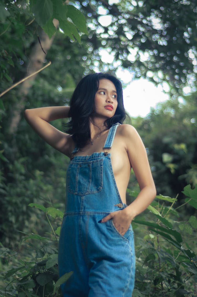 Woman In Jean Overalls In Forest