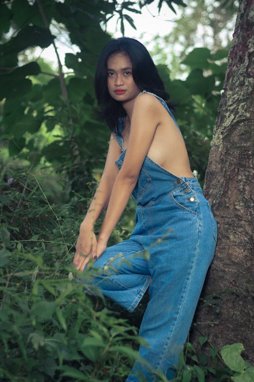 Woman in Jean Overalls in Forest