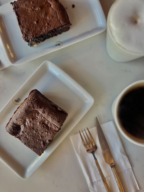 Top View of Slices of Chocolate Cake and Coffees on a Table 