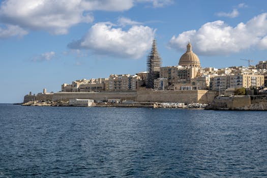 A picturesque view of Valletta's skyline featuring St. Paul's Cathedral and waterfront under a blue sky.