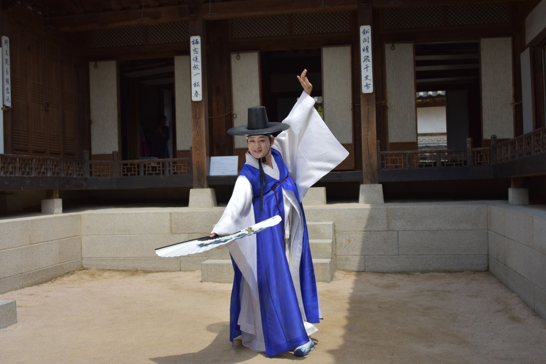 Asian woman posing in traditional Korean attire at a temple, showcasing cultural heritage.