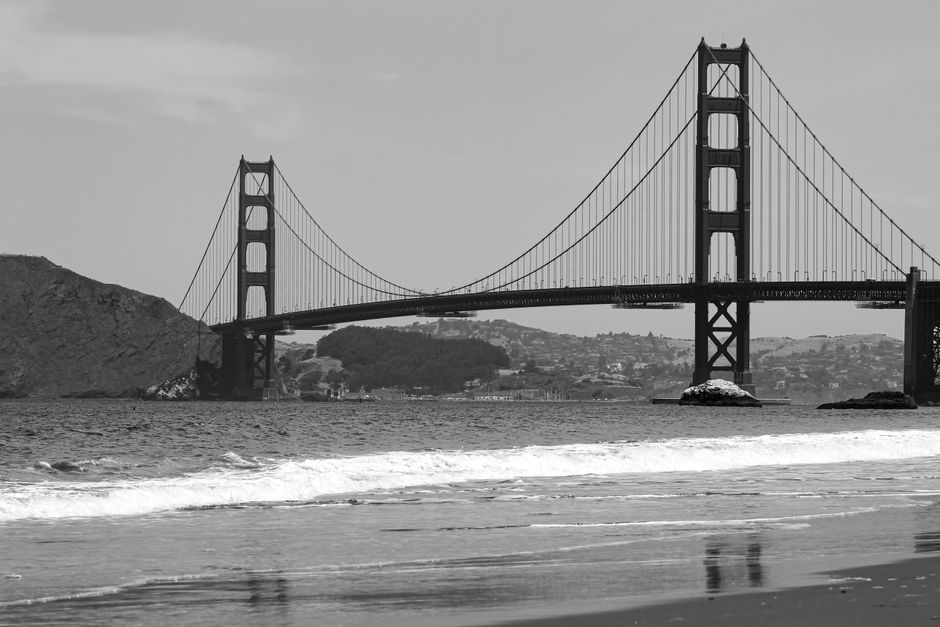 Iconic view of the Golden Gate Bridge spanning San Francisco Bay captured in black and white.