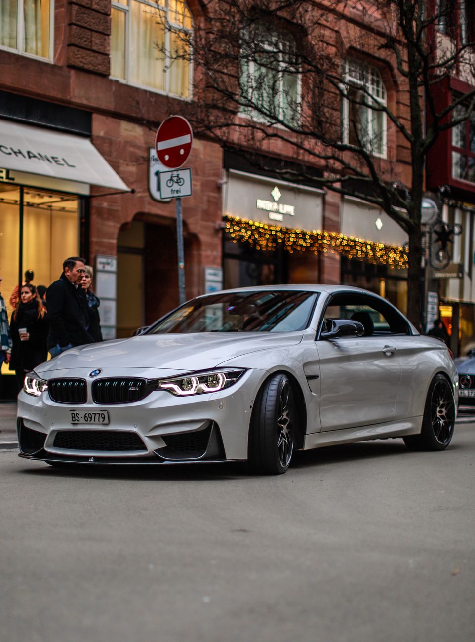 A sleek silver car on a city street.