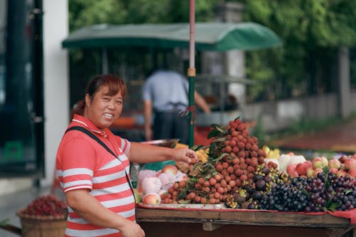 Woman Selling Fresh Fruit of a Market Stall 