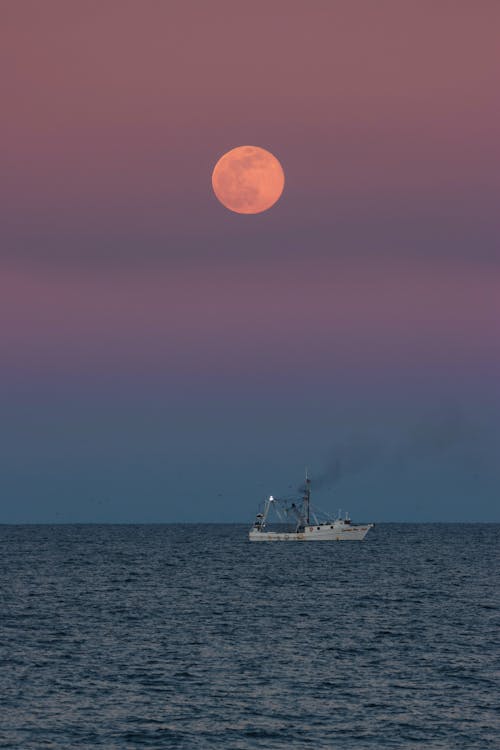 Ship Sailing on the Sea under a Full Moon in the Sky