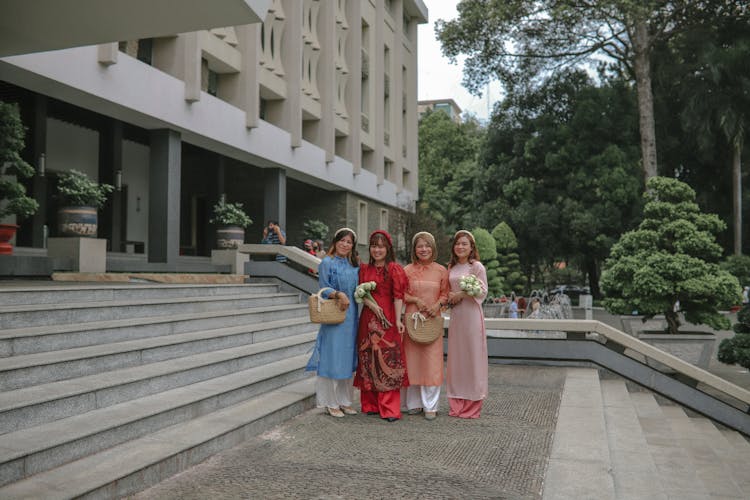 A Group Of Women Smiling While Wearing Ao Dai