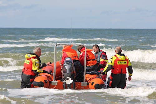 A Group of Lifeguards Standing in the Water with a Rescue Craft 